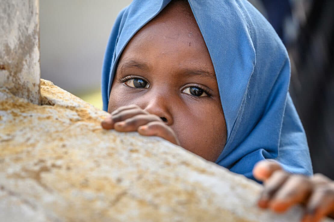 Una ragazza curiosa al Centro sanitario materno-infantile Darusalam a Baidoa, Somalia. Finanziato da Global Affairs Canada e gestito da World Vision.