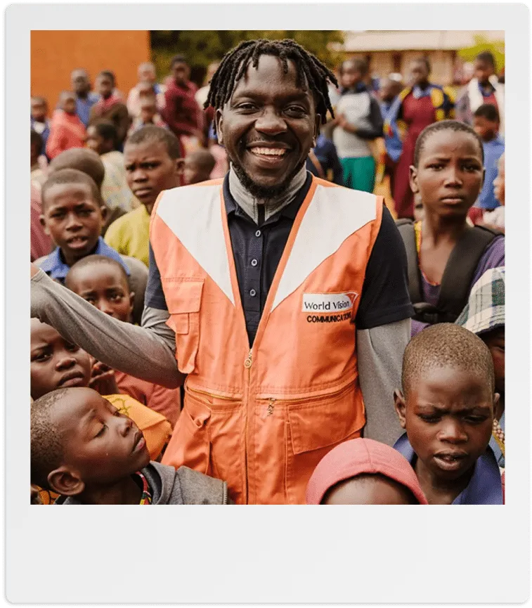 Immagine di World Vision che promuove l'area 'Lavora con noi'. Presenta una polaroid stilizzata con l'icona di una figura umana all'interno, accompagnata da simboli che richiamano il lavoro di squadra e l'impegno sociale. L'immagine invita a unirsi all'organizzazione per fare la differenza.